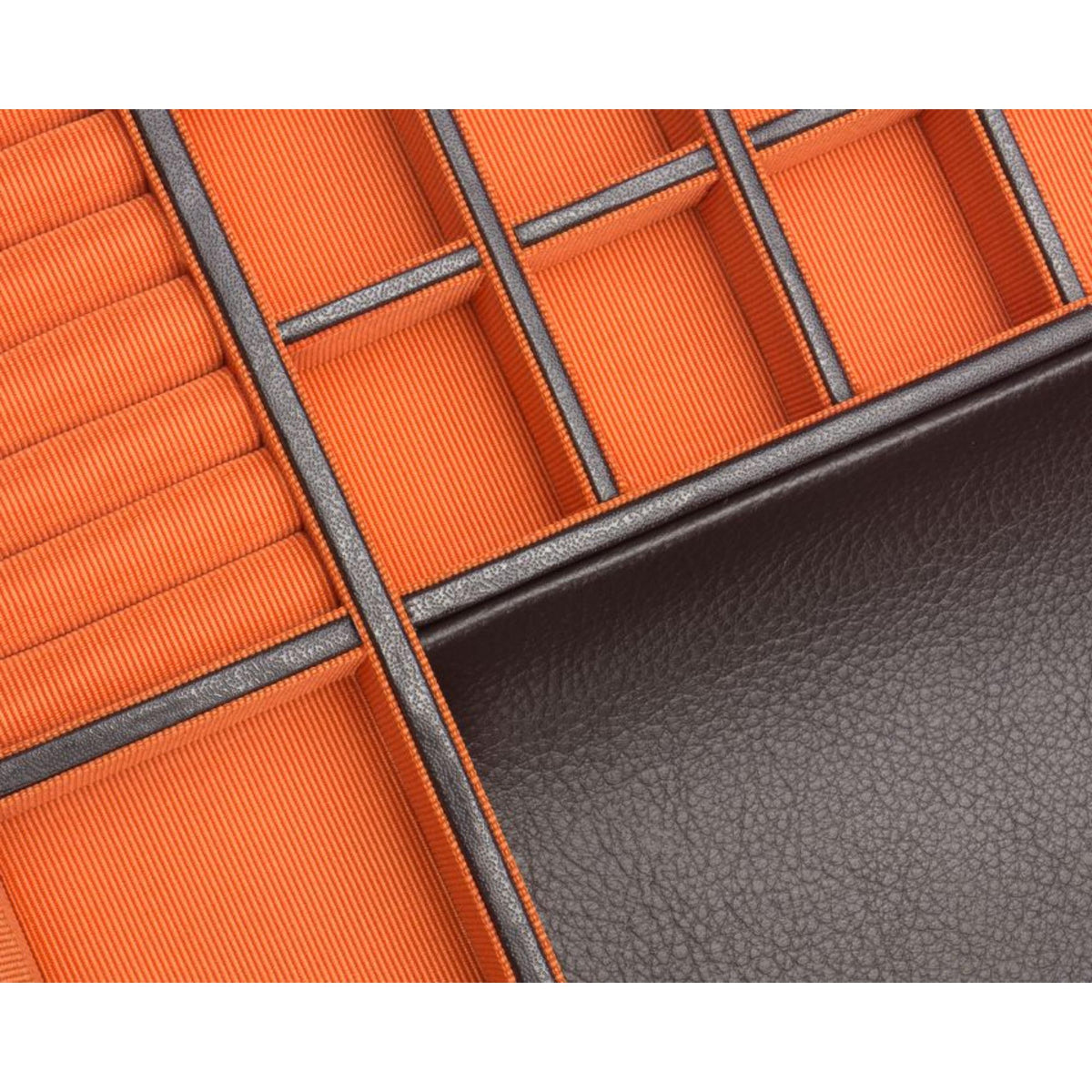 Close-up of orange padded compartments bordered by dark leather and grid dividers.