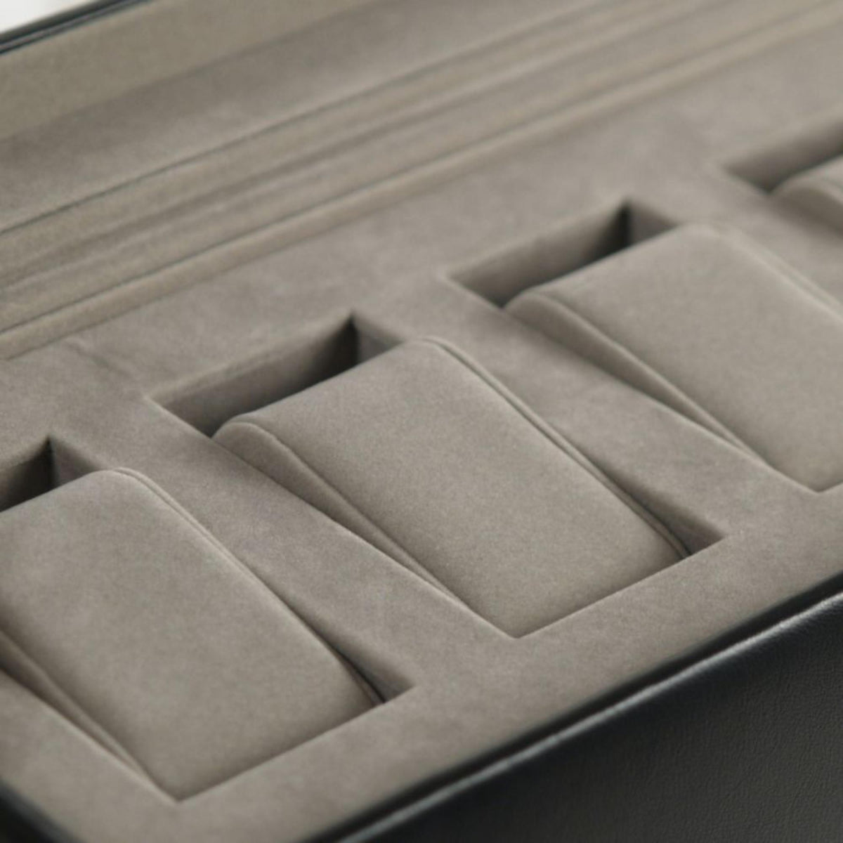 Close-up of gray padded watch slots inside the black watch box