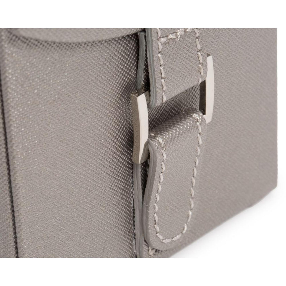 Close-up of tan jewelry box hinge and stitched handle loop with metal snap