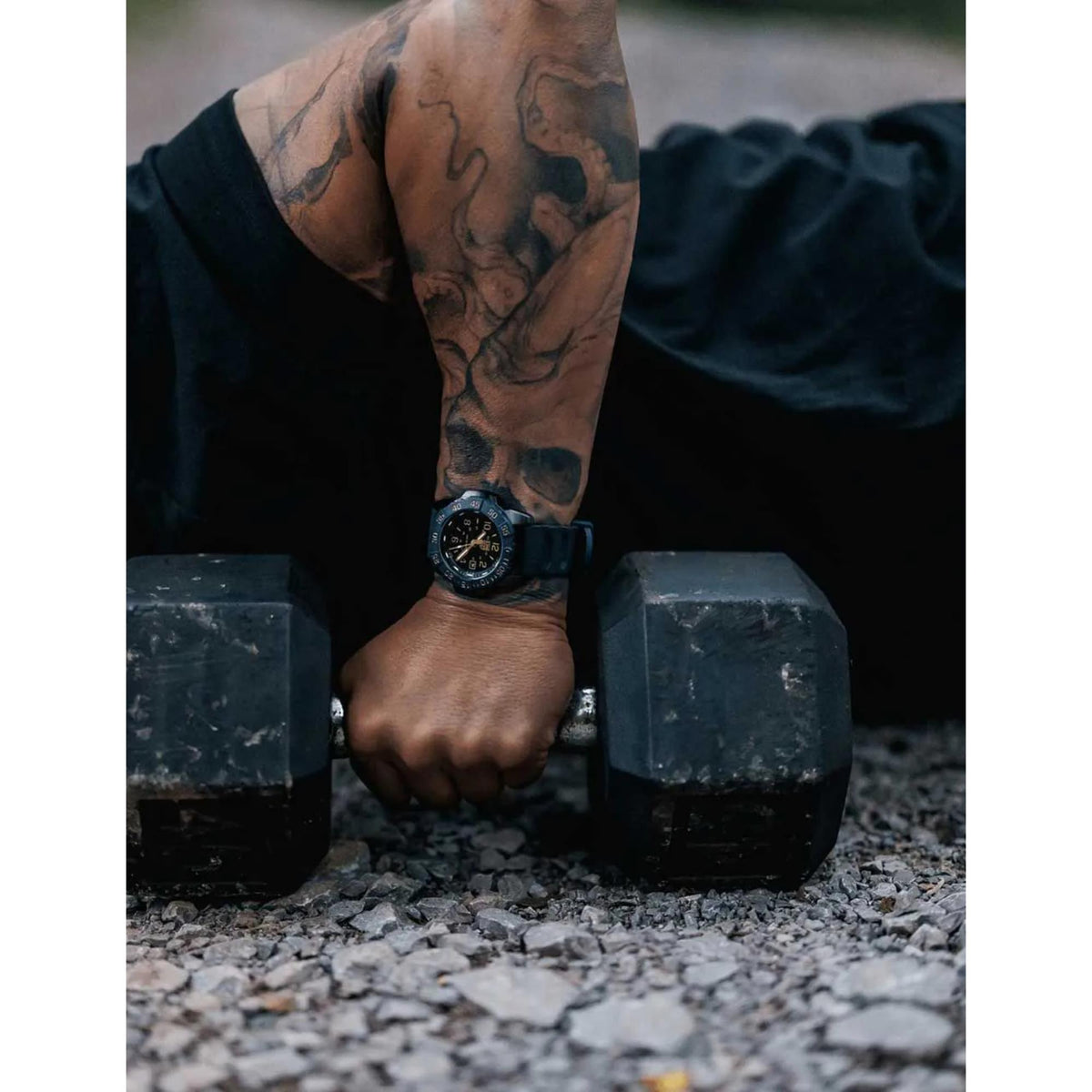 Men's blue rubber strap quartz diver watch worn on forearm, black dial visible
