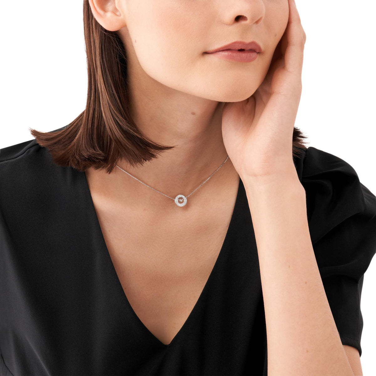 Sterling silver pendant necklace with round logo charm on thin chain, model wearing