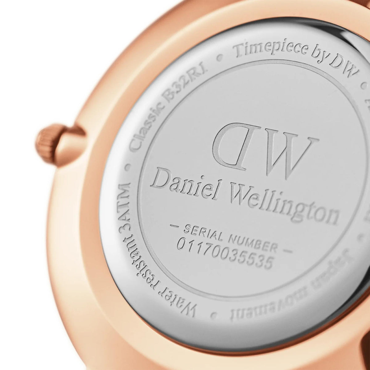 Rose-gold tone watch caseback with Daniel Wellington logo and serial number details