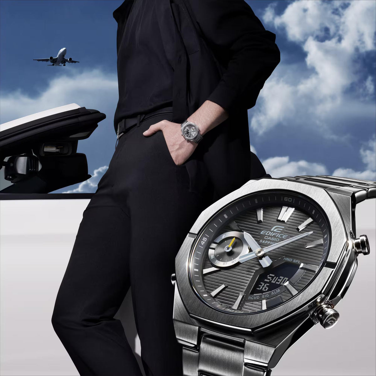 Men's stainless steel wristwatch with grey dial on a dressed wrist.
