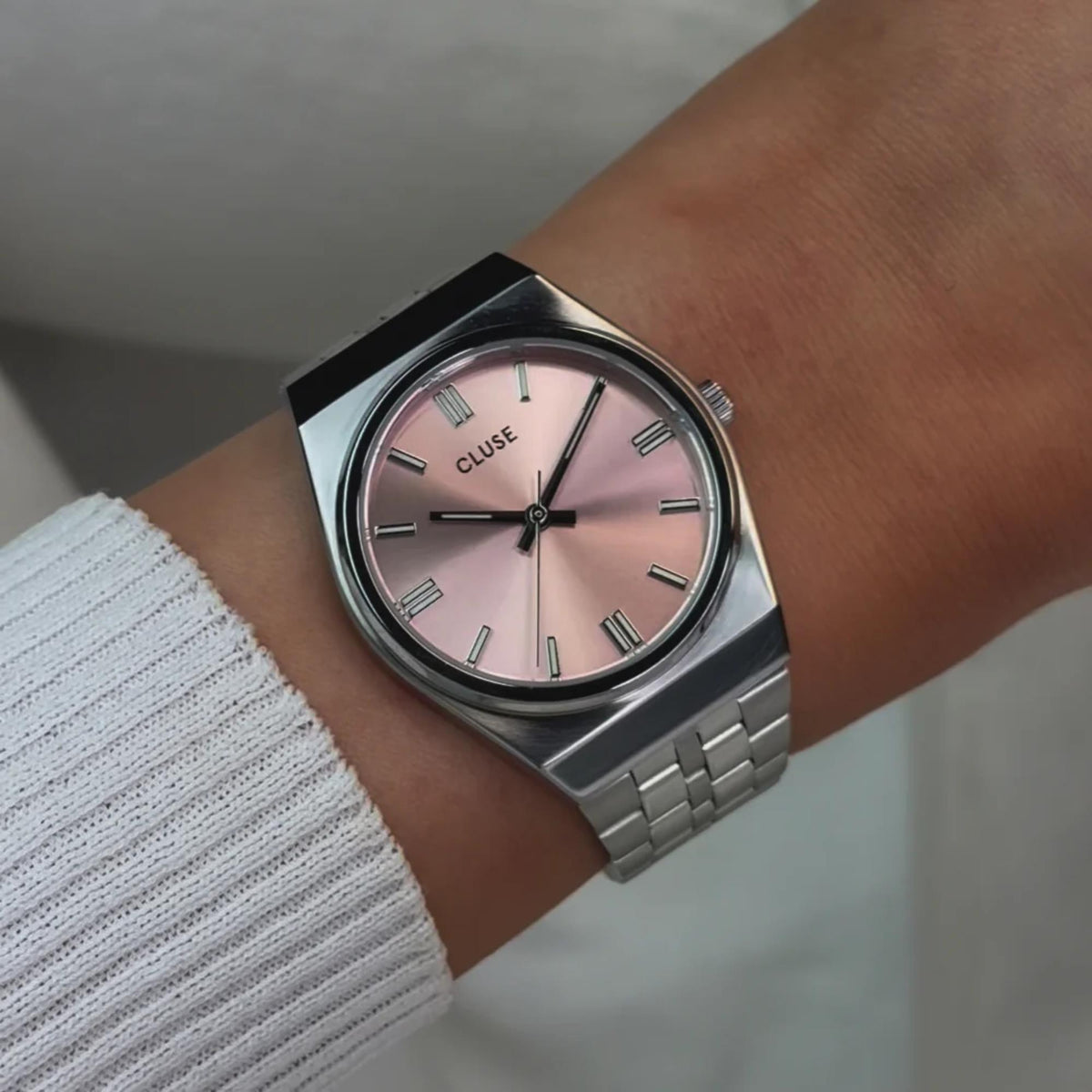 Women's steel wristwatch with pink dial, slim hands, and link bracelet
