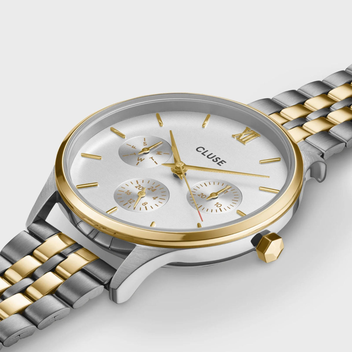 Two-tone chronograph watch close-up with white dial, gold indices, and subdials