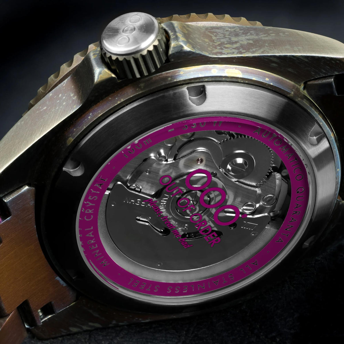 Men's automatic watch movement close-up with magenta ring on steel caseback
