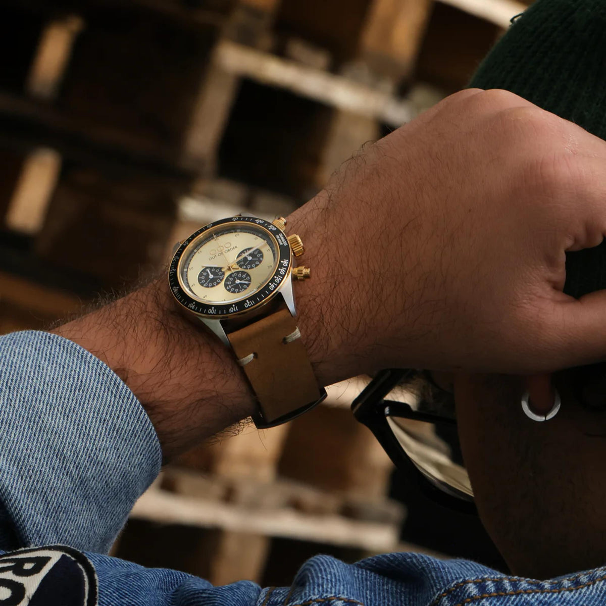 Men's gold chronograph watch worn on wrist with brown leather strap and subdials