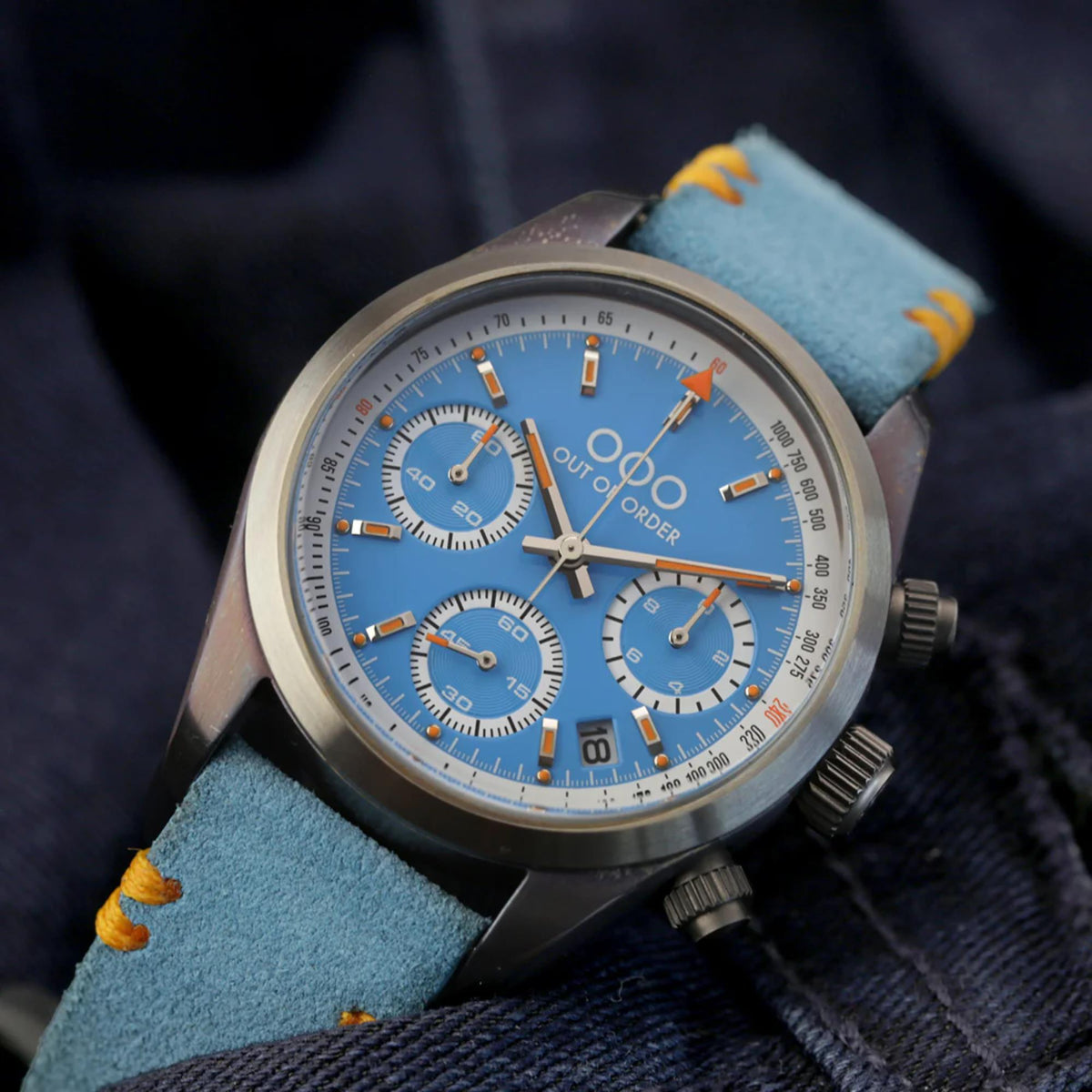 Sporty chronograph watch with light blue dial, three subdials, and blue fabric strap