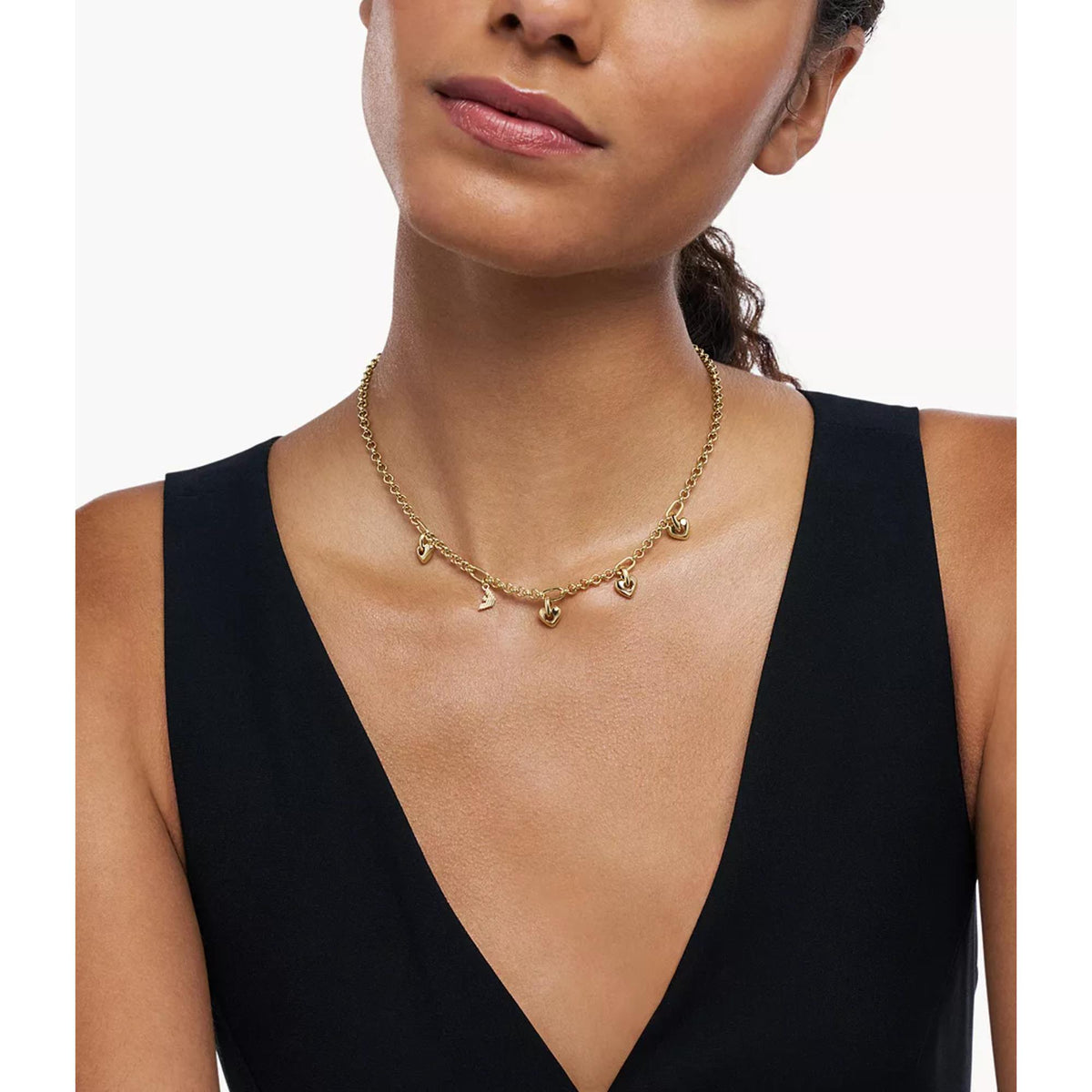 Gold-tone charm pendant necklace shown on a model with a V-neck dress