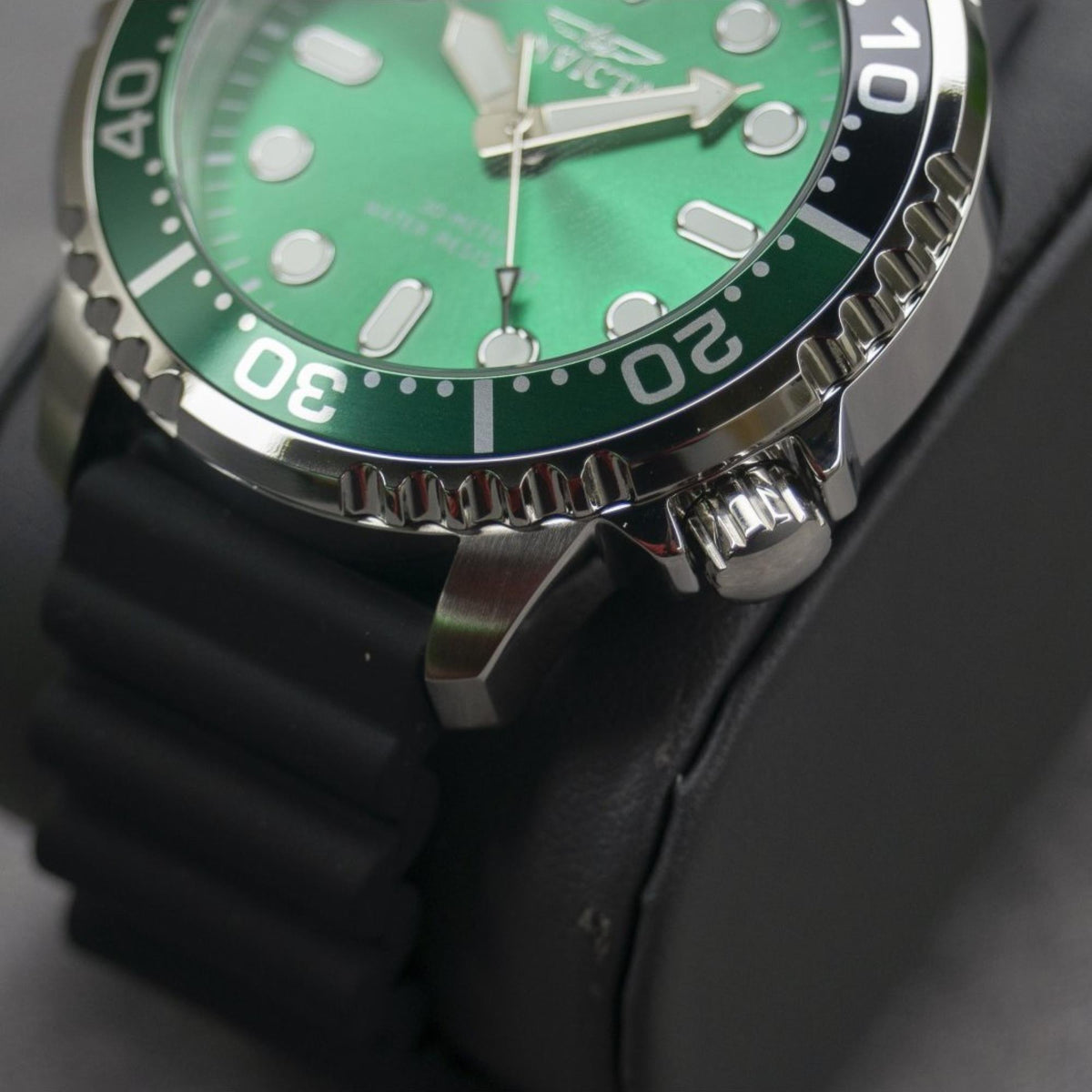 Men's dive watch side view: black silicone strap, green dial, stainless bezel with ridged edge