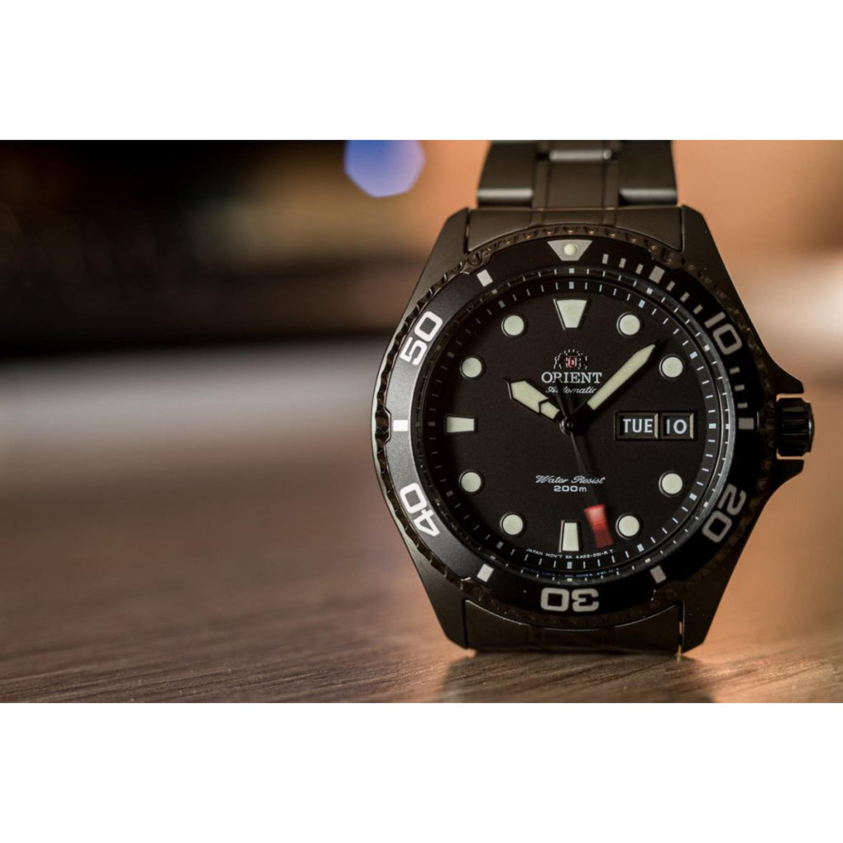 Men's automatic diver watch on wooden surface, black dial and date window