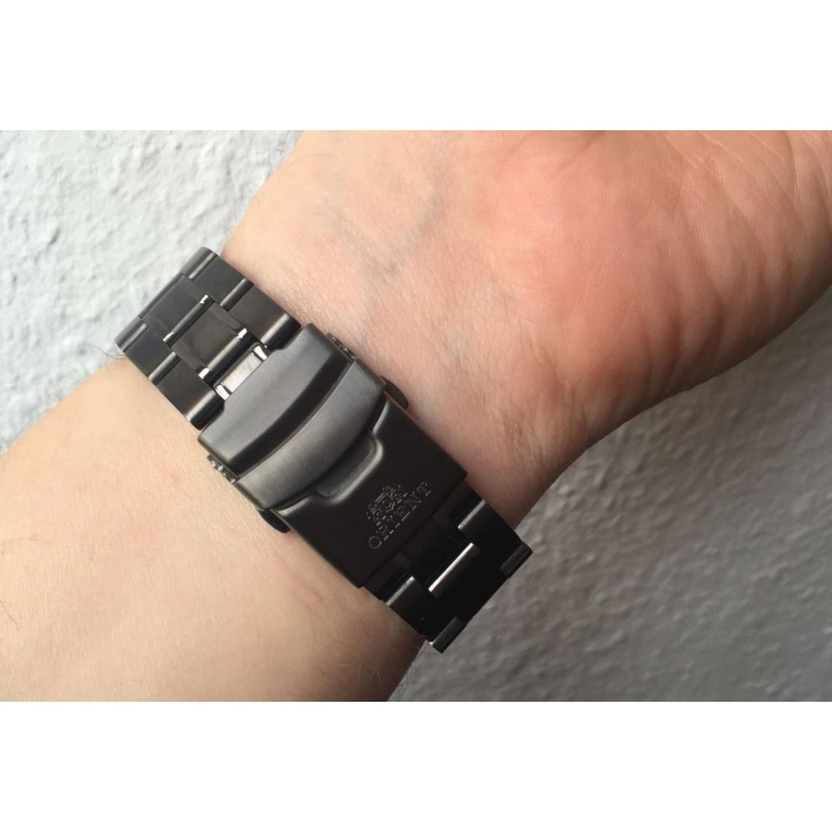 Men's automatic watch clasp view with black steel bracelet and ORIENT branding