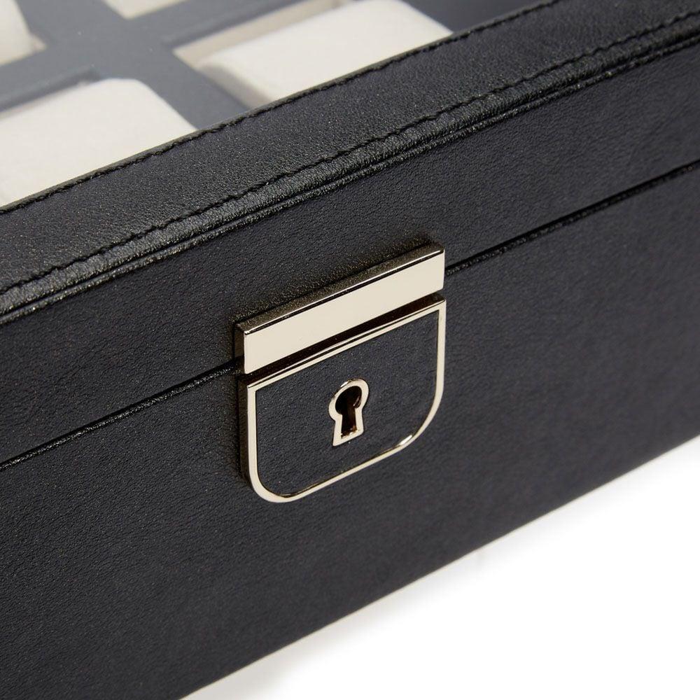 Close-up of black watch box lock with gold-tone keyhole plate