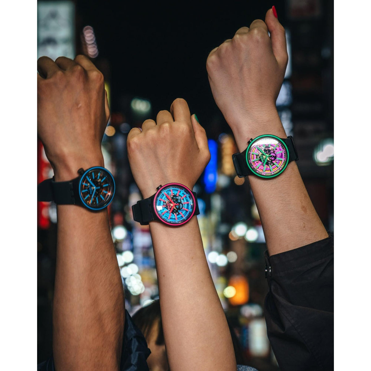 Swatch blue dial silicone strap watches with pink accents on multiple wrists