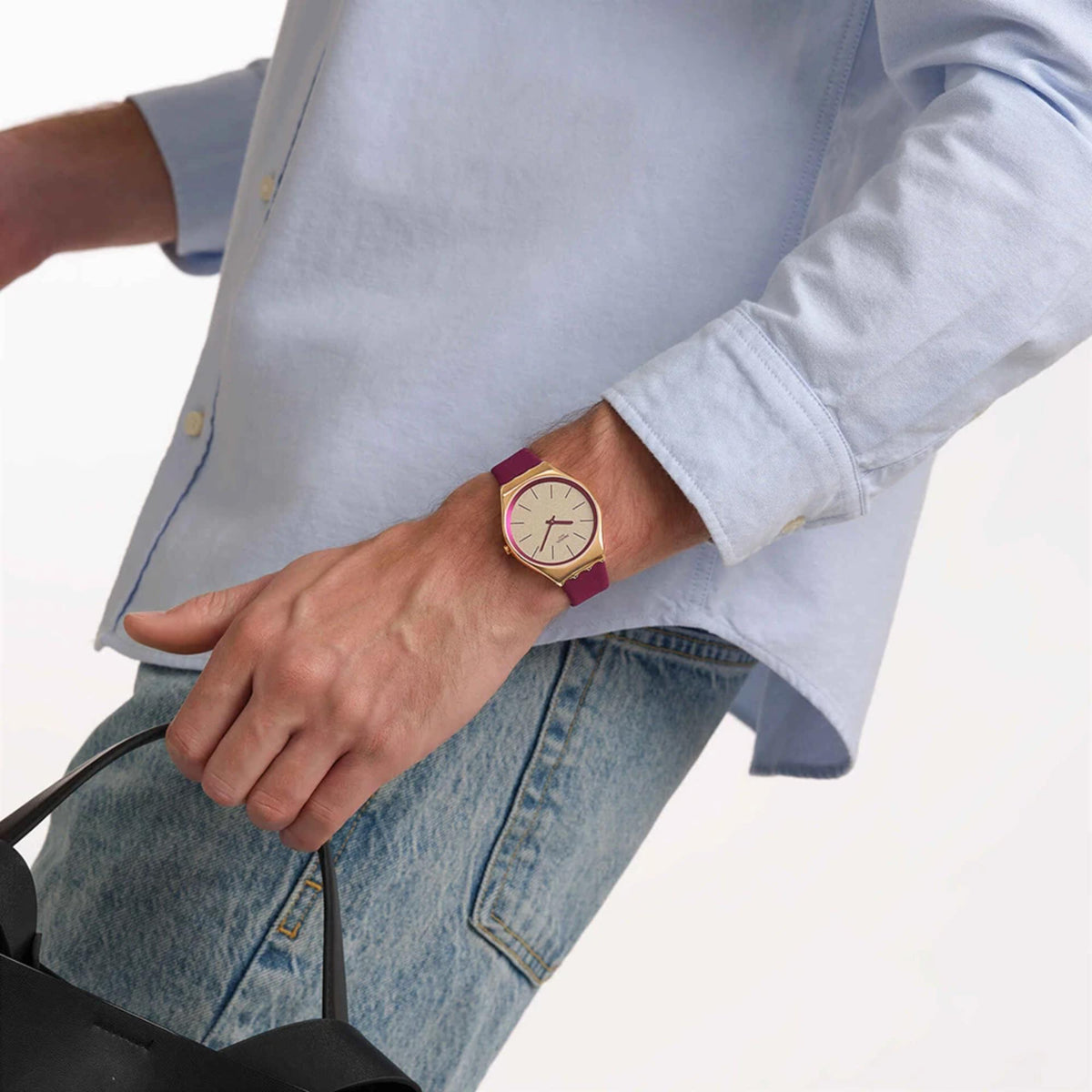 Burgundy leather strap watch on wrist, cream dial, gold-tone case, red hands