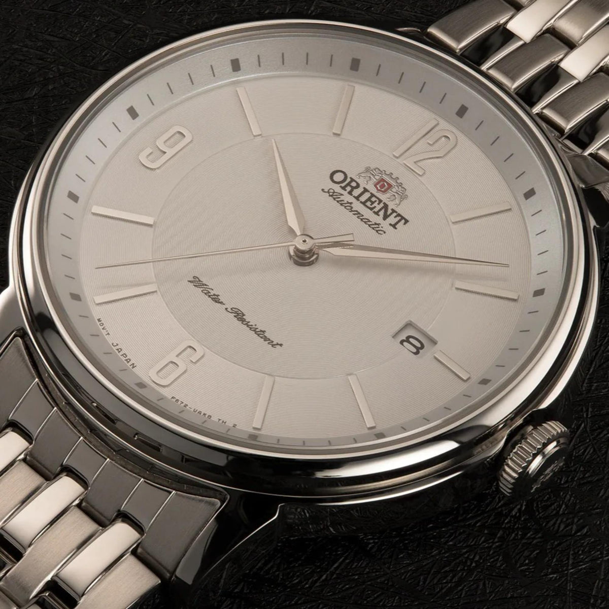 Mens automatic watch with white dial, three hands, ORIENT emblem on metal bracelet