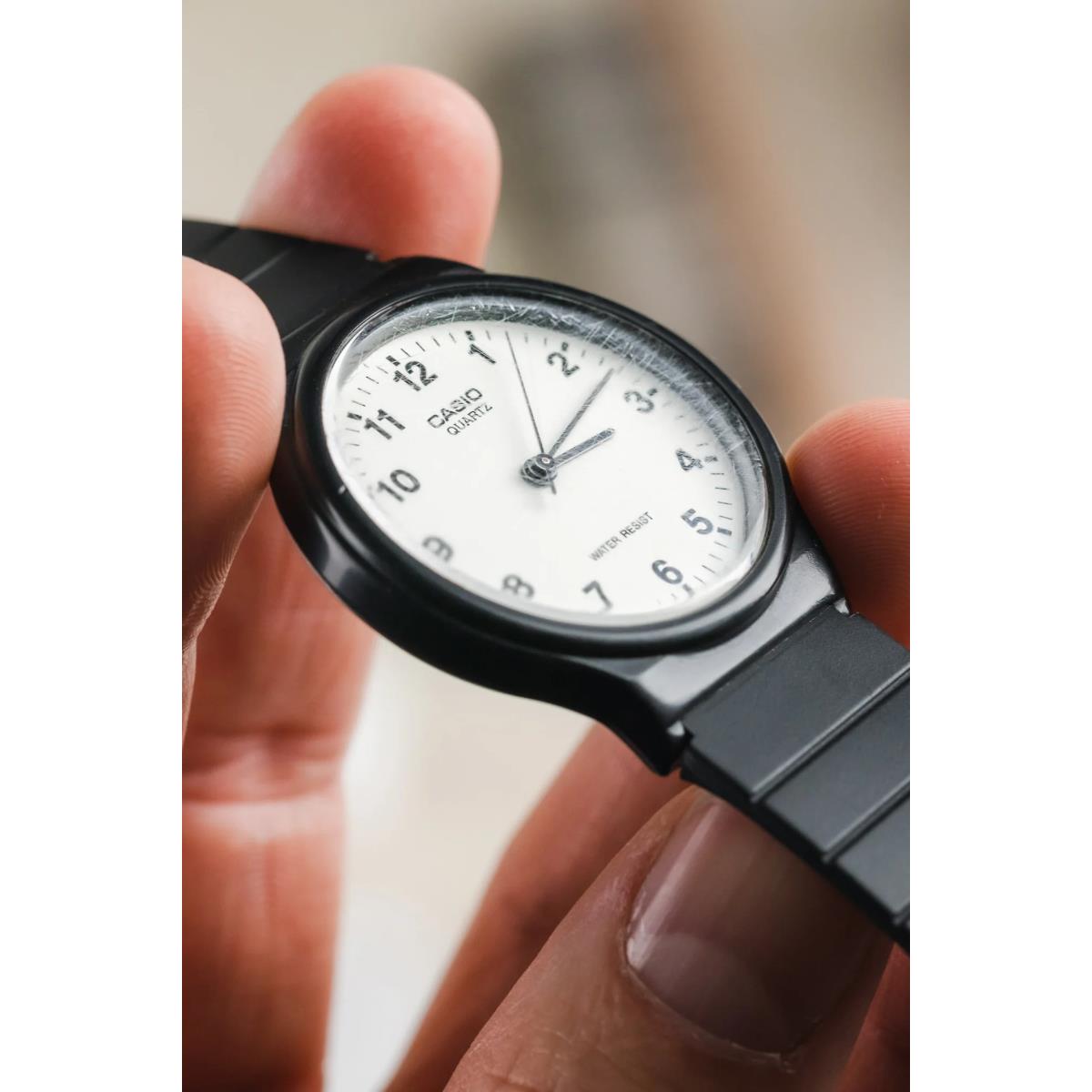 Close-up of black wristwatch crystal while being polished by hand