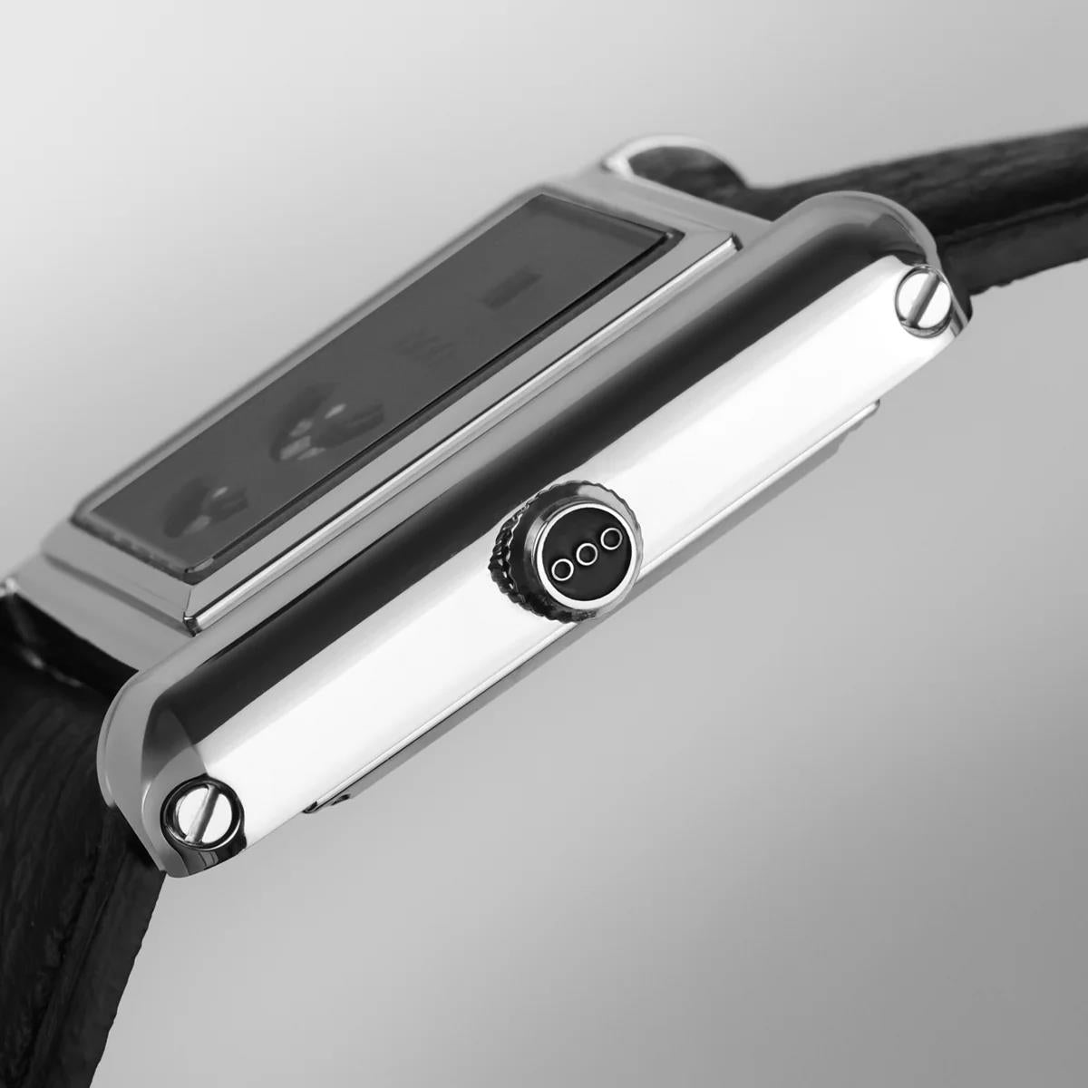 Side view of black leather strap watch, silver-tone case with crown and round button