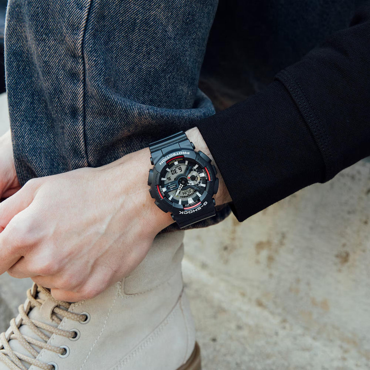 Black resin G-Shock digital-analog watch on wrist with red accents