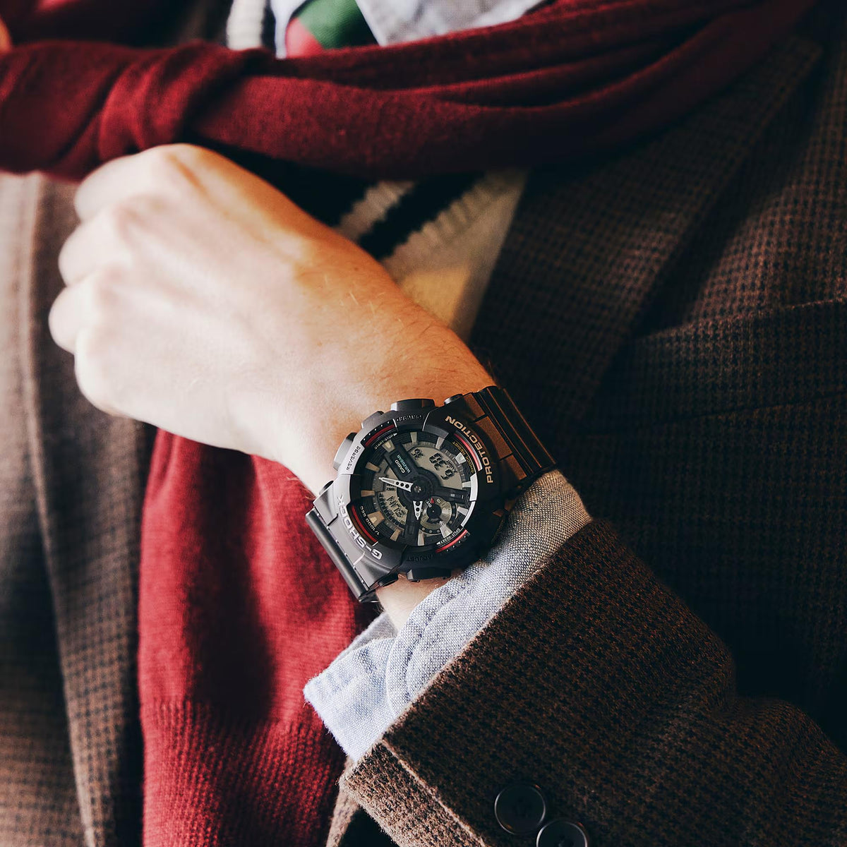 Black resin G-Shock sport watch on wrist, digital-analog dial with red accents