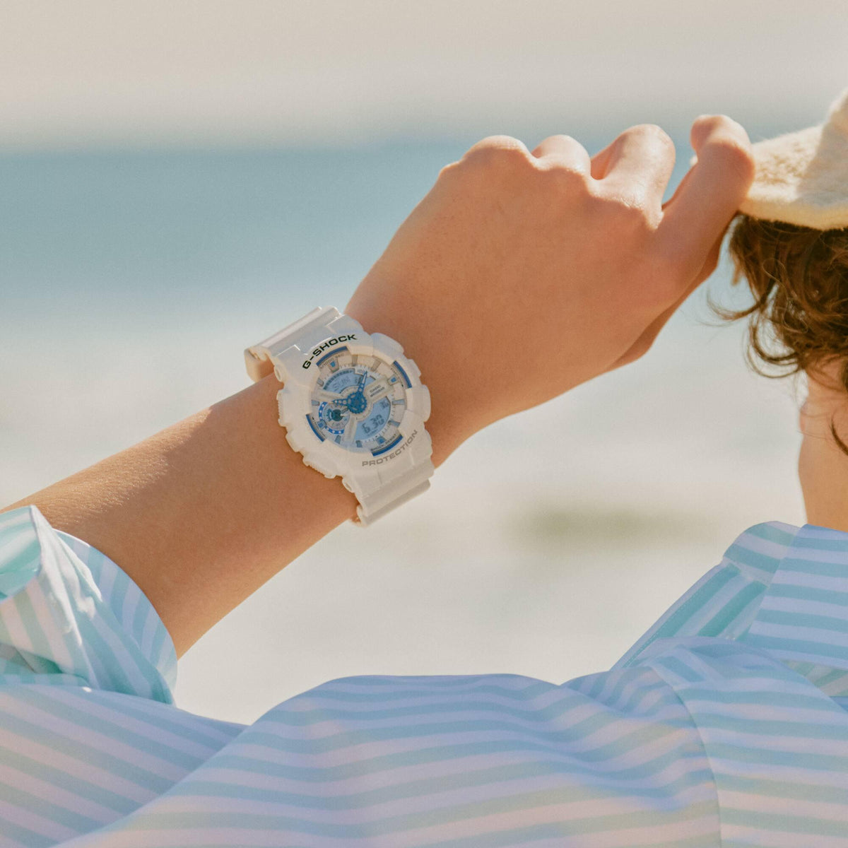 White resin G-Shock digital-analogue watch with blue dial detail, worn on wrist