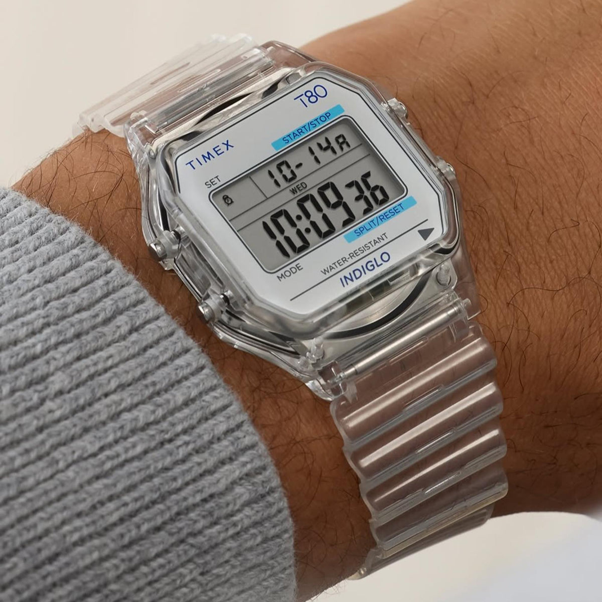 Transparent digital resin quartz watch on wrist with LCD showing time and date