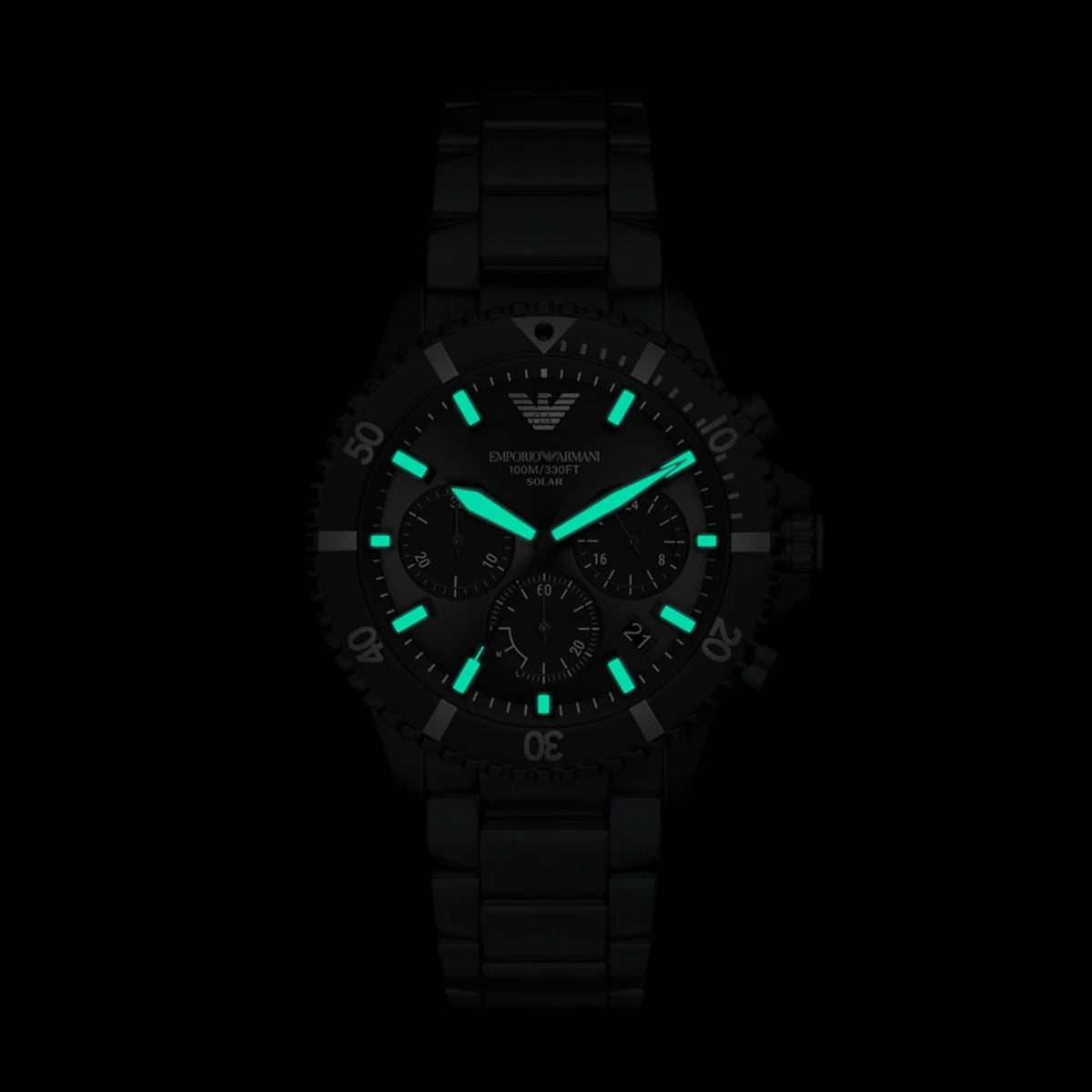 Front view of Emporio Armani Dario AR11784 watch in total darkness, highlighting the bright green luminescent hands and indices