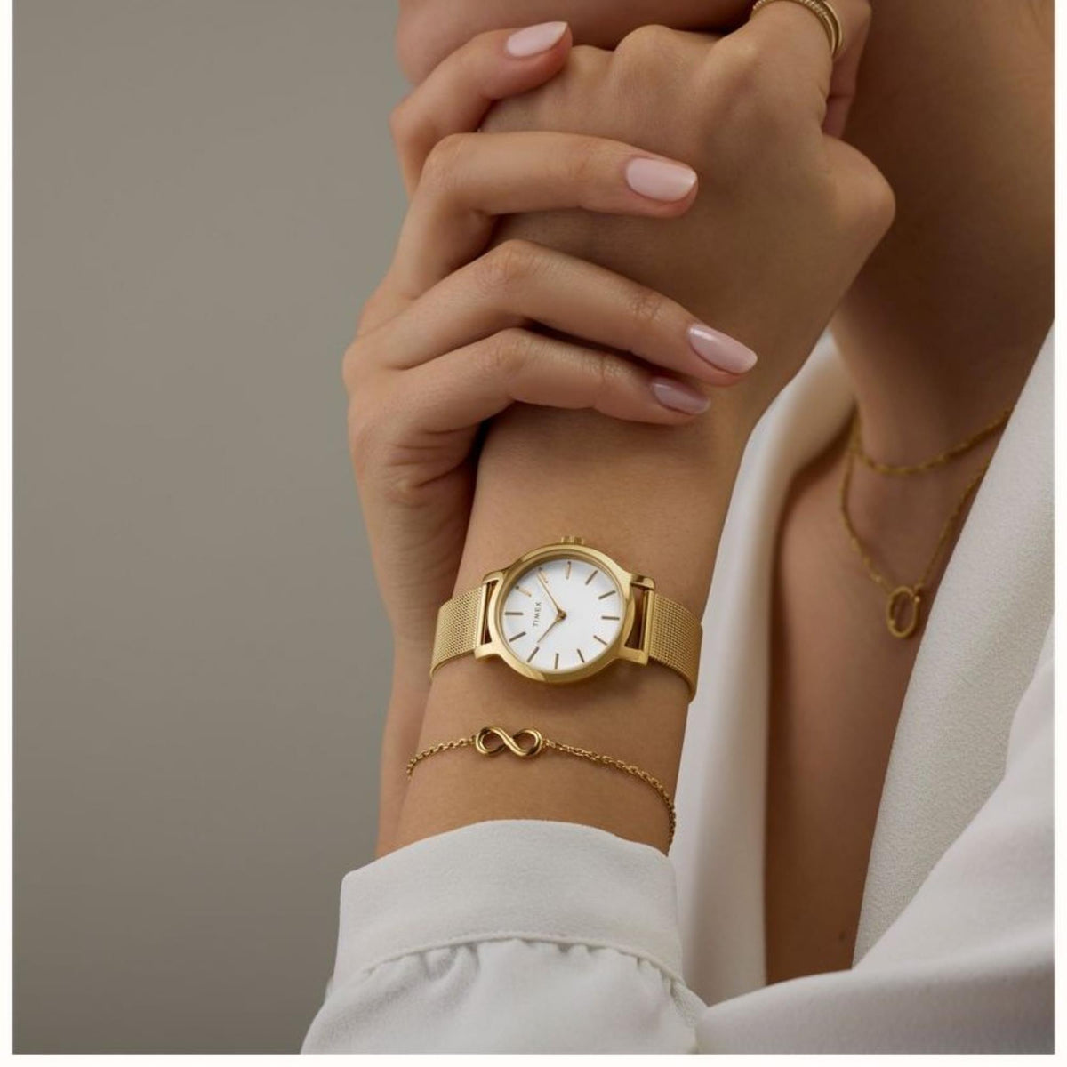 Timex ladies quartz watch on wrist with white dial and gold-tone mesh strap