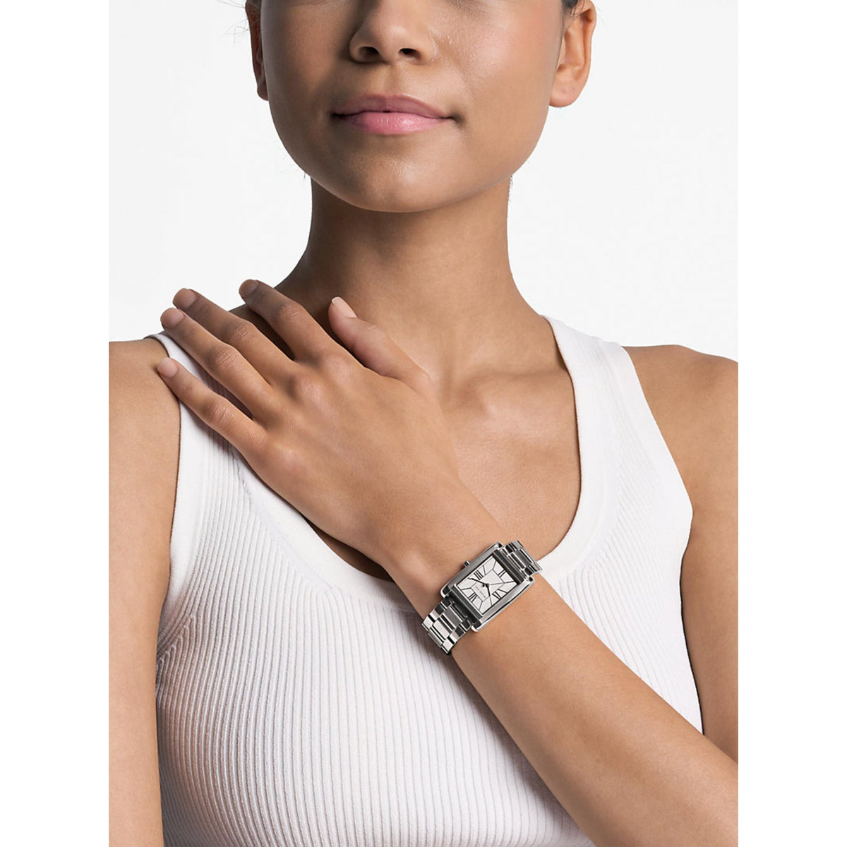 Michael Kors Essex MK4906 women's watch styled on a wrist displaying the silver dial, rectangular case, and steel bracelet