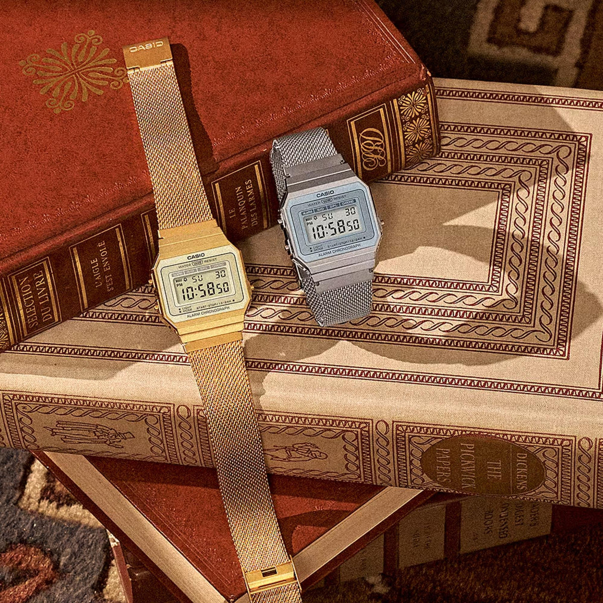 Casio Vintage Mini A700WEM-7AEF silver and gold mesh strap models on books
