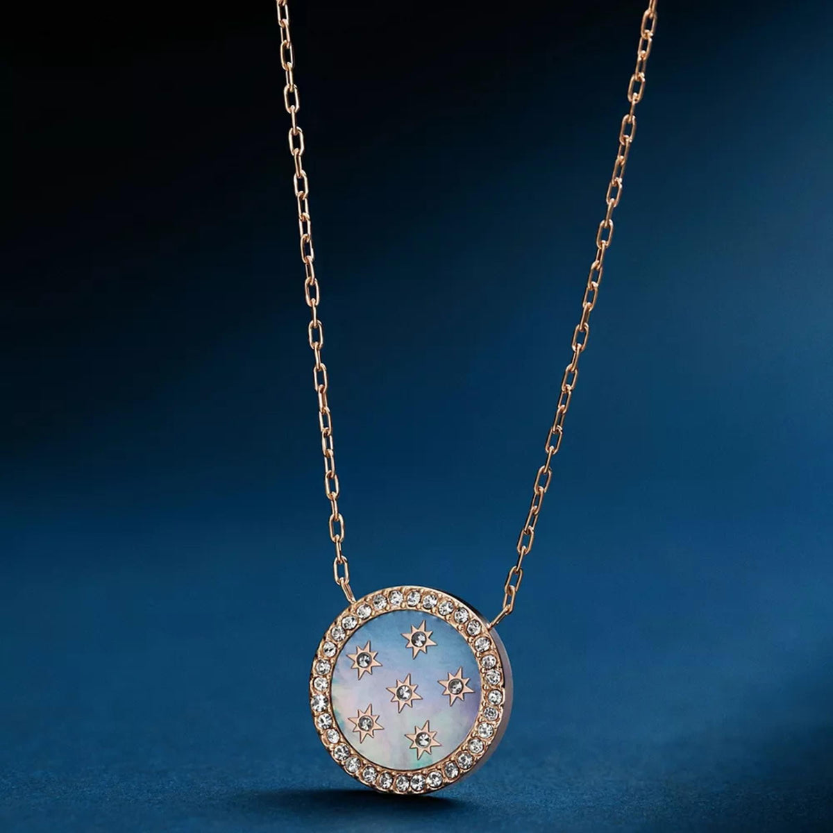 Rose gold-tone pendant necklace with round mother-of-pearl disc, star motif, crystal border