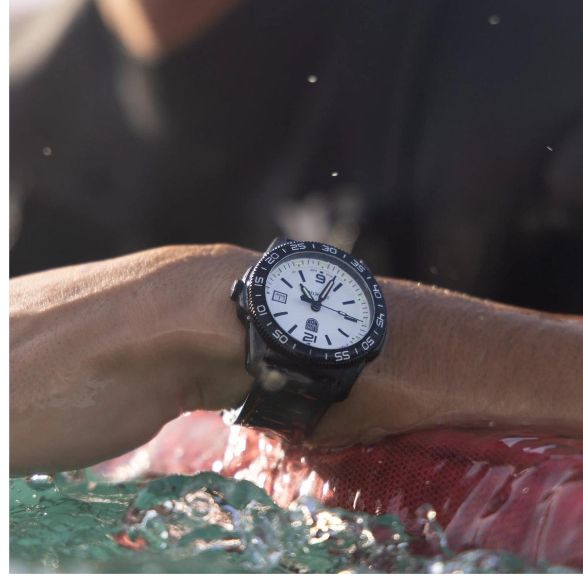 Wrist shot of the Luminox Pacific Diver XS.3127M white dial tactical watch emerging from splashing water
