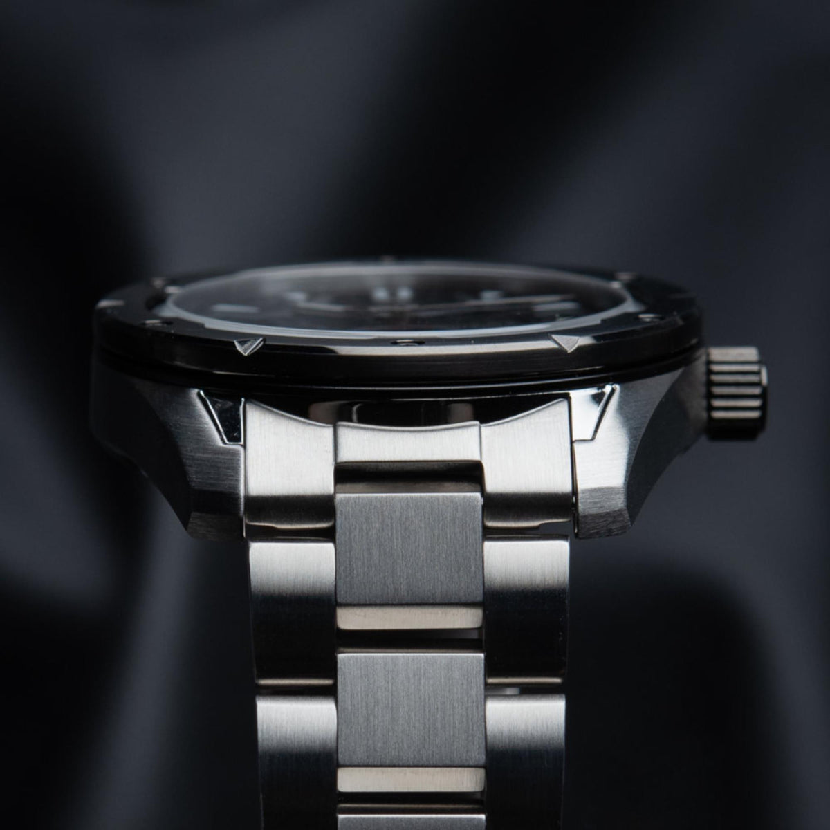 Men's automatic watch side view, stainless steel bracelet and knurled crown.