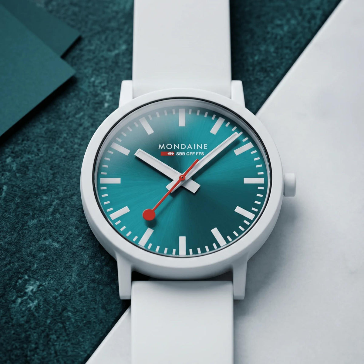 Men's quartz wristwatch with teal dial, white bezel, and white silicone strap