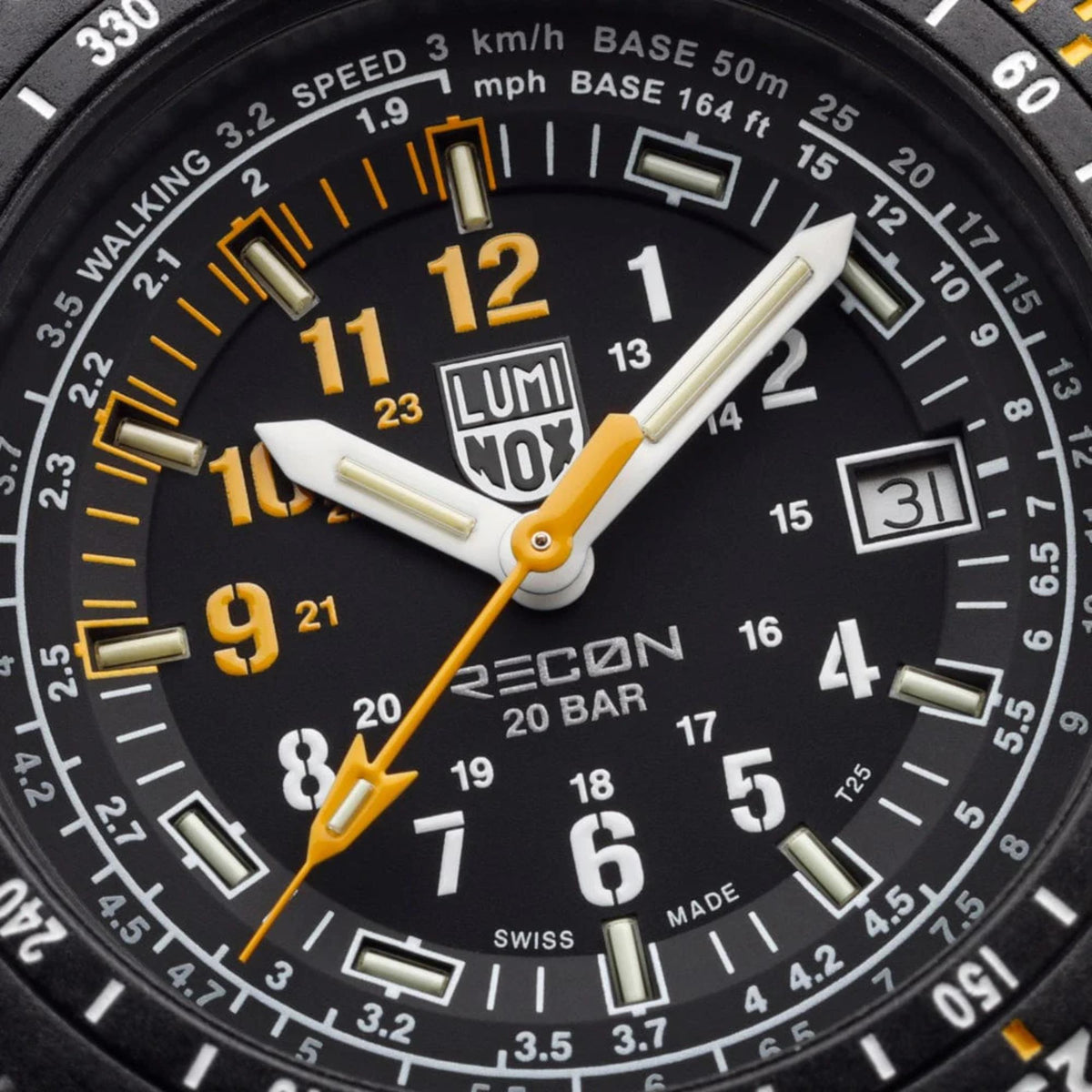 Close-up of black watch dial with yellow numerals, white markers, and gold-tone hands