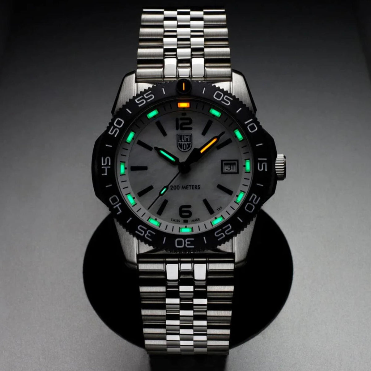 Steel diver watch with black dial, luminous markers, date window, textured dive bezel, bracelet