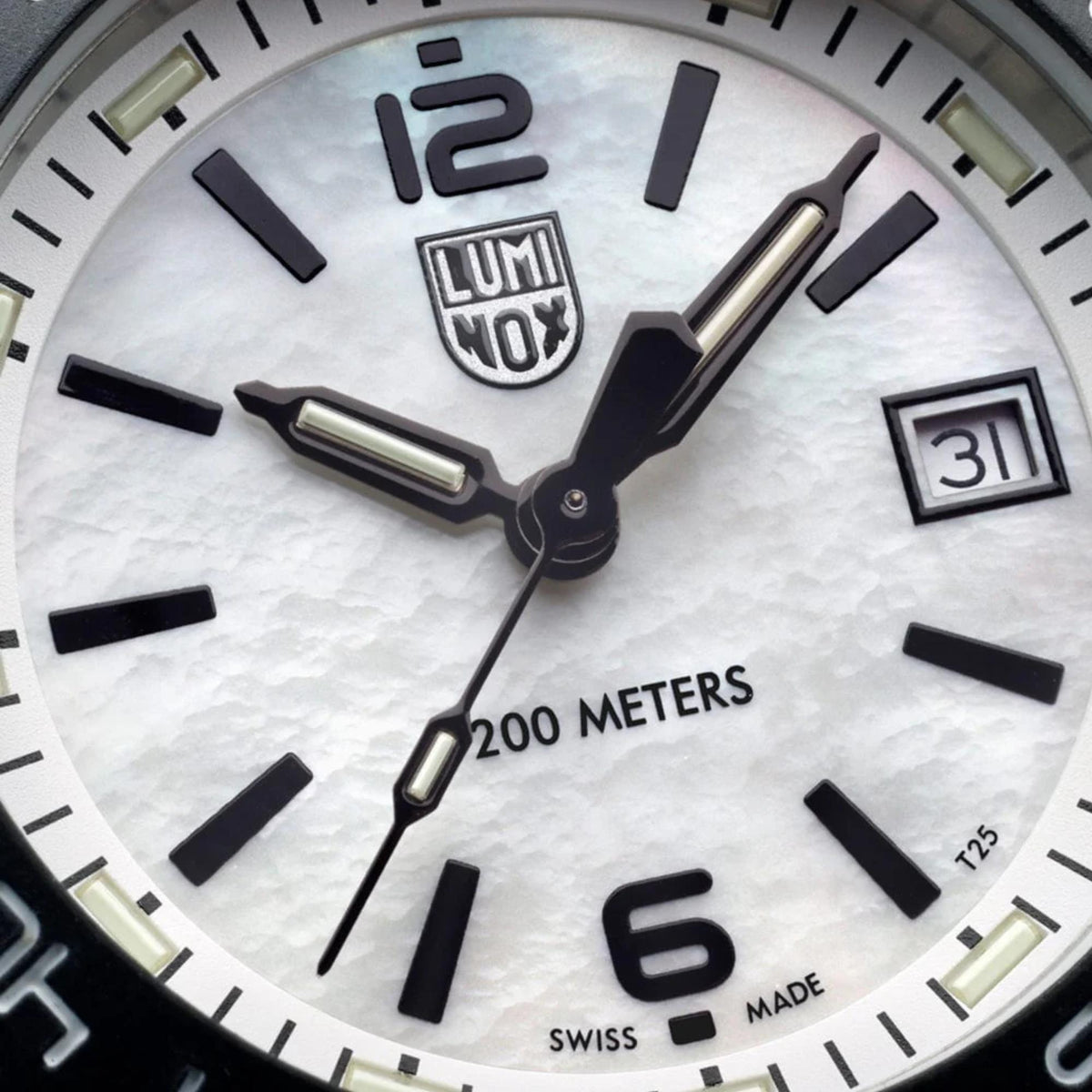 Close-up of white dial diver watch with lume hands and markers, date window at 3 o'clock