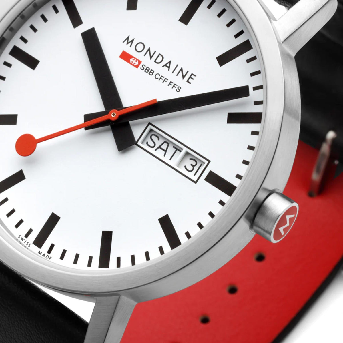 Extreme close-up of Mondaine Classic A667.30360.11SBBV analog dial displaying red second hand, day-date calendar function, and red-emblemed crown