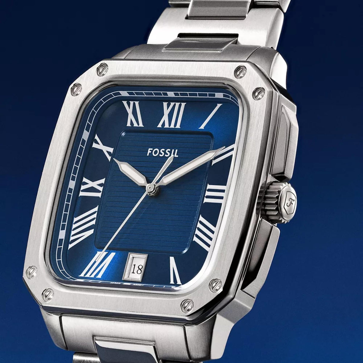 Angled close-up of the Fossil Crosby FS6121 timepiece highlighting the textured blue dial, date display, Roman numerals, and screw-detailed bezel