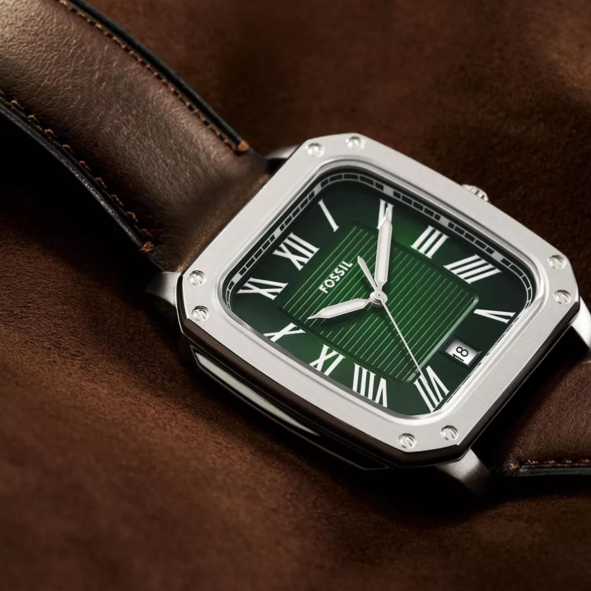 Angled close-up view of the Fossil Crosby FS6150 timepiece resting on brown leather, featuring a textured green dial with Roman numerals