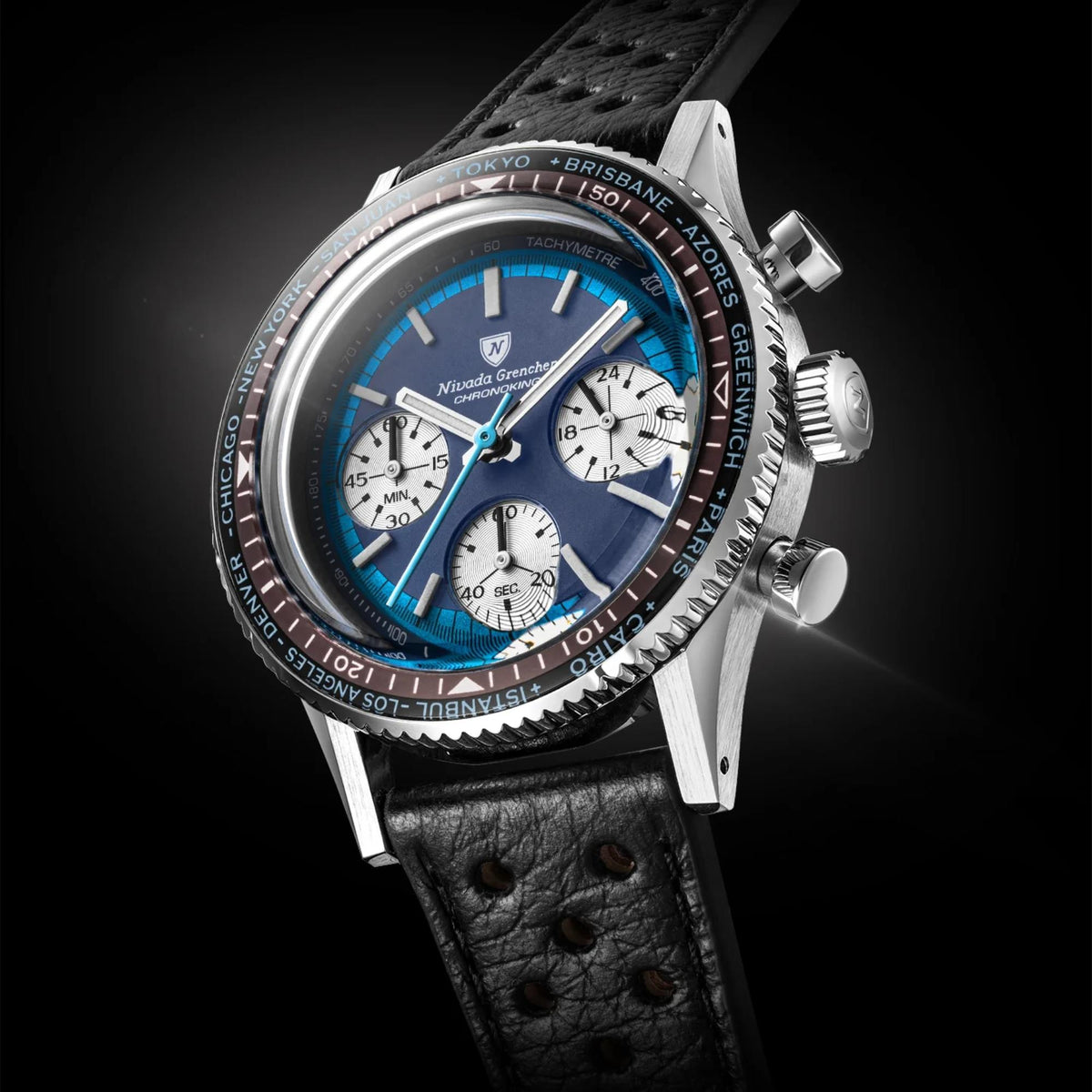 Nivada Grenchen Chronoking watch with a stainless steel case, a blue dial with white subdials, a black leather strap, and a black bezel with white and red markings, shown against a dark background