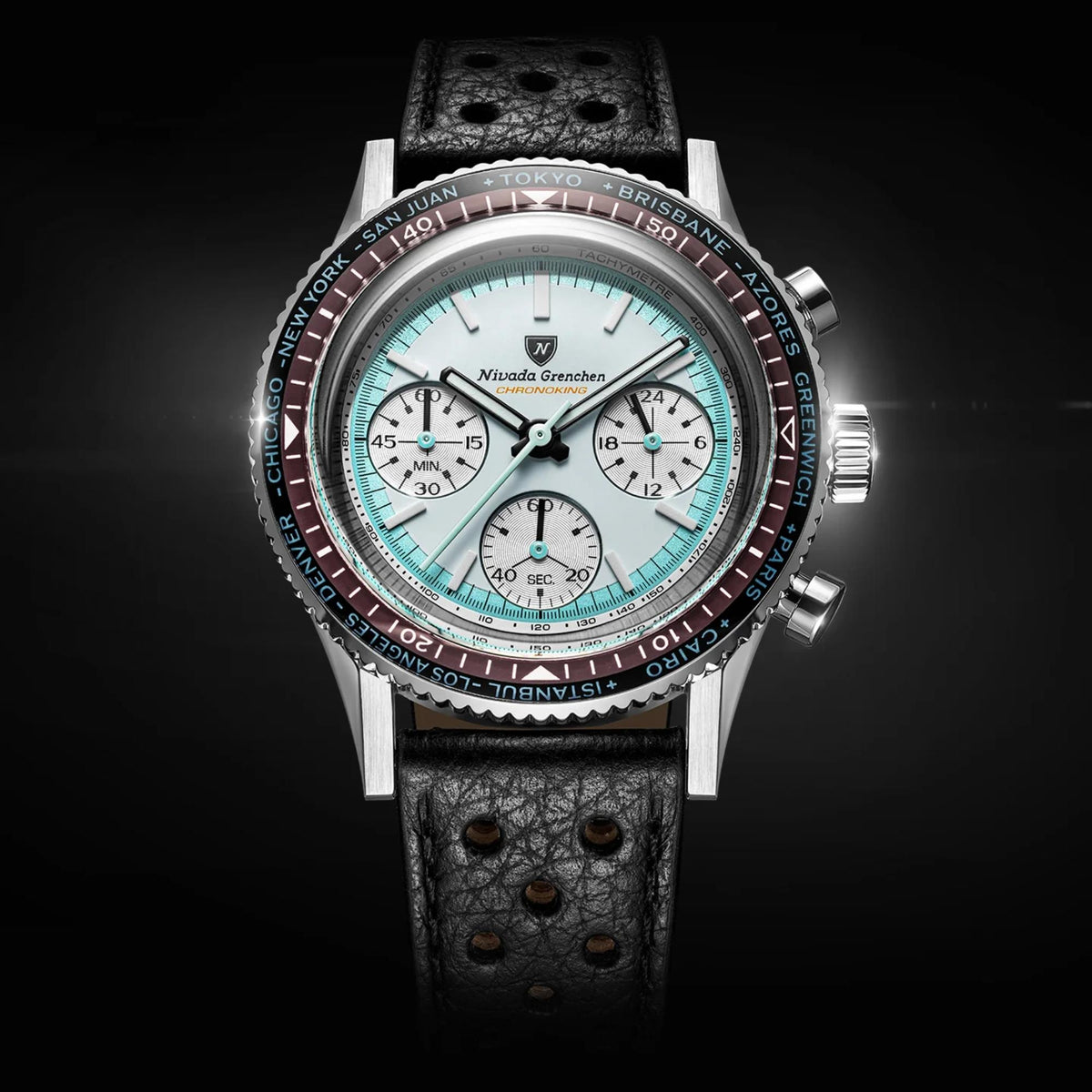 Nivada Grenchen Chronoking watch with a silver-toned case, a white dial, a red and black tachymeter bezel, and a black textured leather strap, shown against a dark background