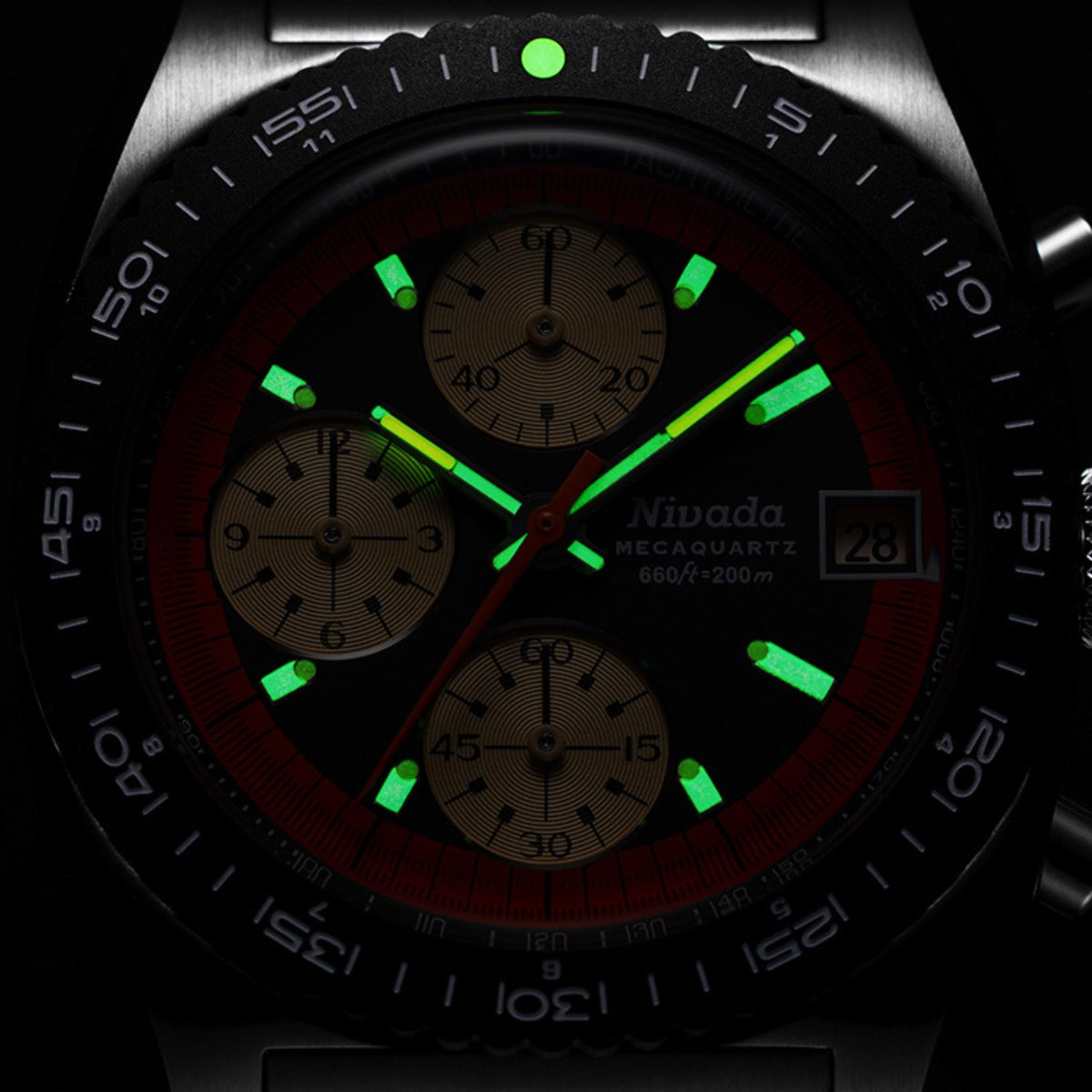 Nivada Grenchen Autochron Mecaquartz 77004Q10 mens wristwatch with green glowing luminous hands and markers in a dark setting