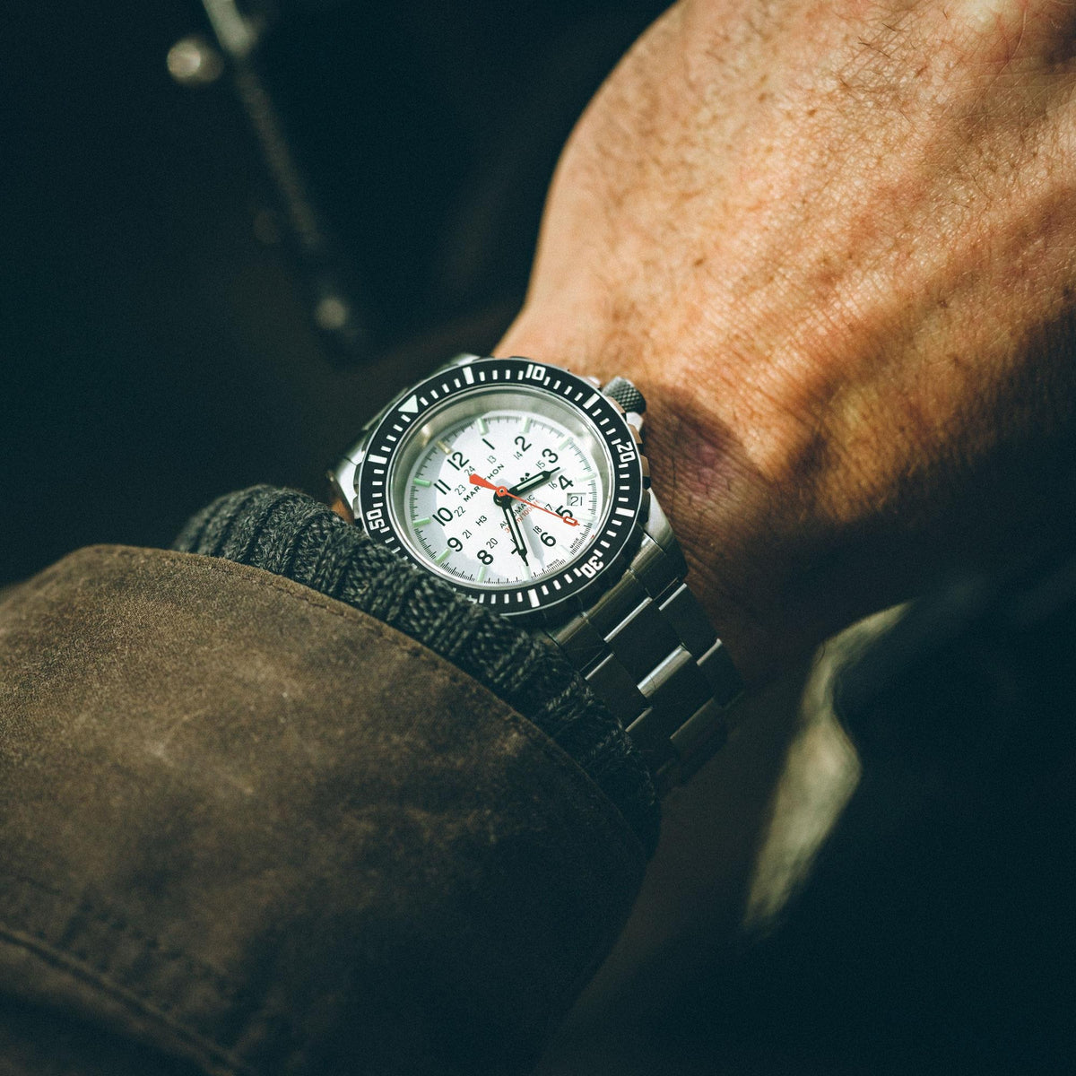Marathon GSAR Arctic Edition WW194006SS-0513 automatic watch displayed on wrist against a dark jacket