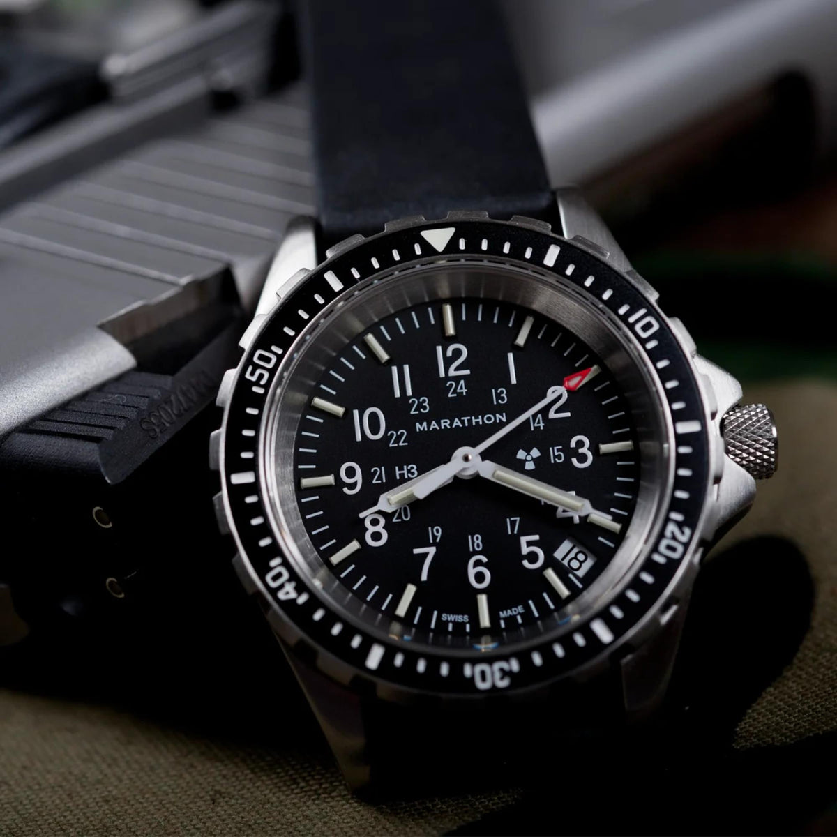 Marathon MSAR WW194027SS-0130 quartz watch macro shot displaying black dial with steel case on dark background