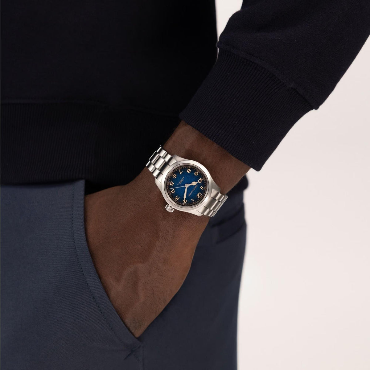 Hamilton Khaki Field Murph H70405140 mens wrist watch on wrist showing blue dial with steel link band and navy sleeve