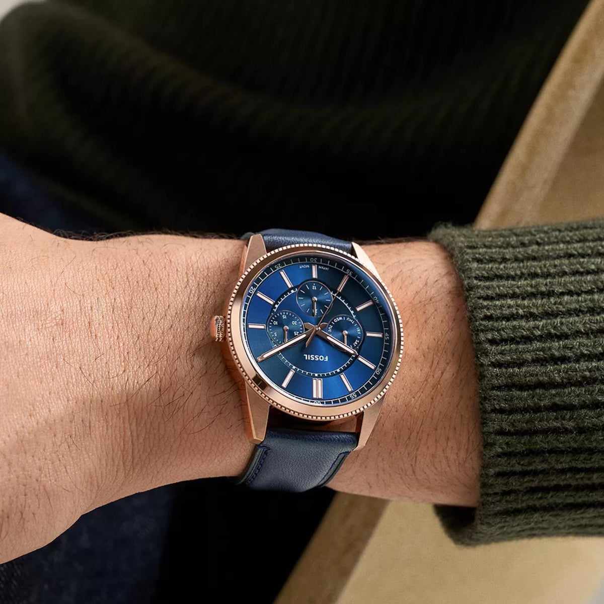 Fossil Pearson FS6196 mens quartz watch on wrist showing round blue dial, sub-dials, and rose gold tone case