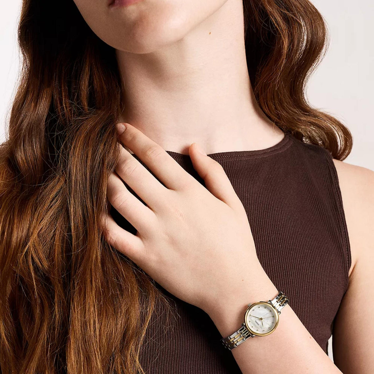 Fossil Heidi ES5500 womens timepiece on wrist featuring mother of pearl dial, gold-tone bezel, and two-tone metal bracelet styled with brown top
