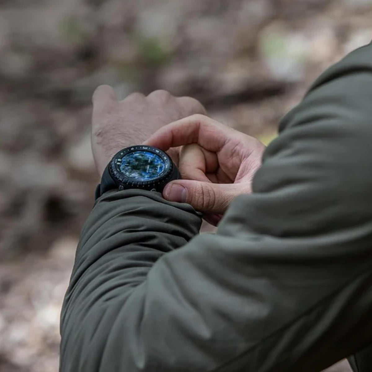 Suunto Core SS014279010 close-up wrist shot of hiker adjusting watch bezel in outdoor environment