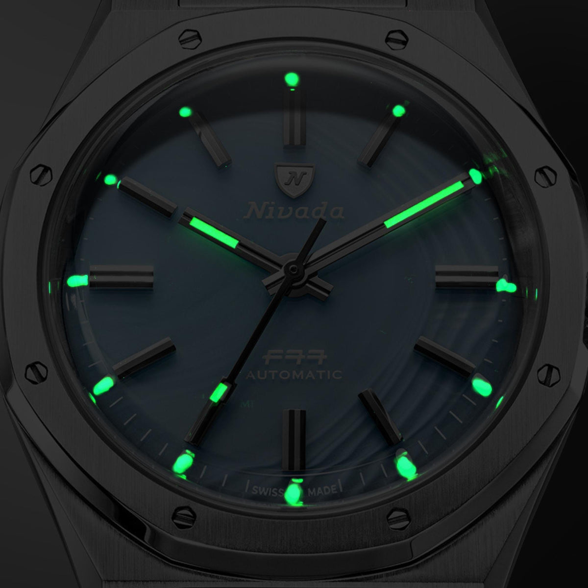 Nivada Grenchen F77 68061A77-BC front view showing luminous hands and indices glowing in low light